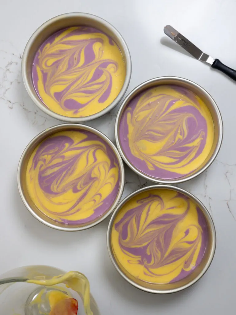 image of lavender lemon cake batter that's been swirled together in cake pans and is ready to be baked