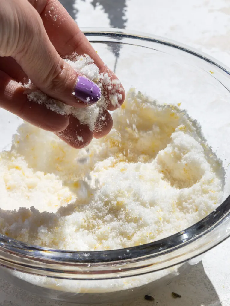 image of lemon zest being rubbed into granulated sugar with fingertips