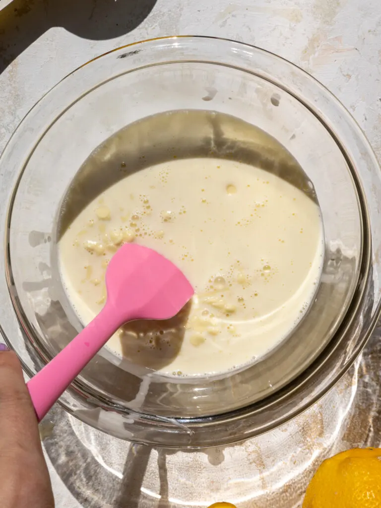 image of heavy cream that's been poured over white chocolate and is sitting to let the heat from the cream melt the white chocolate