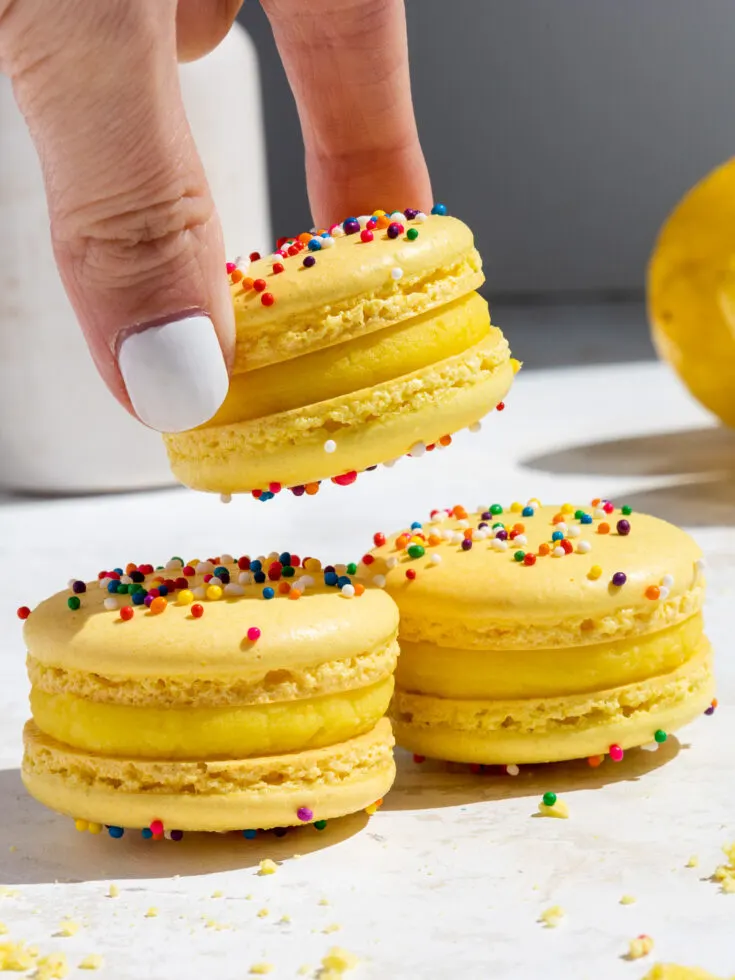 image of macarons filled with lemon ganache being stacked on top of each other