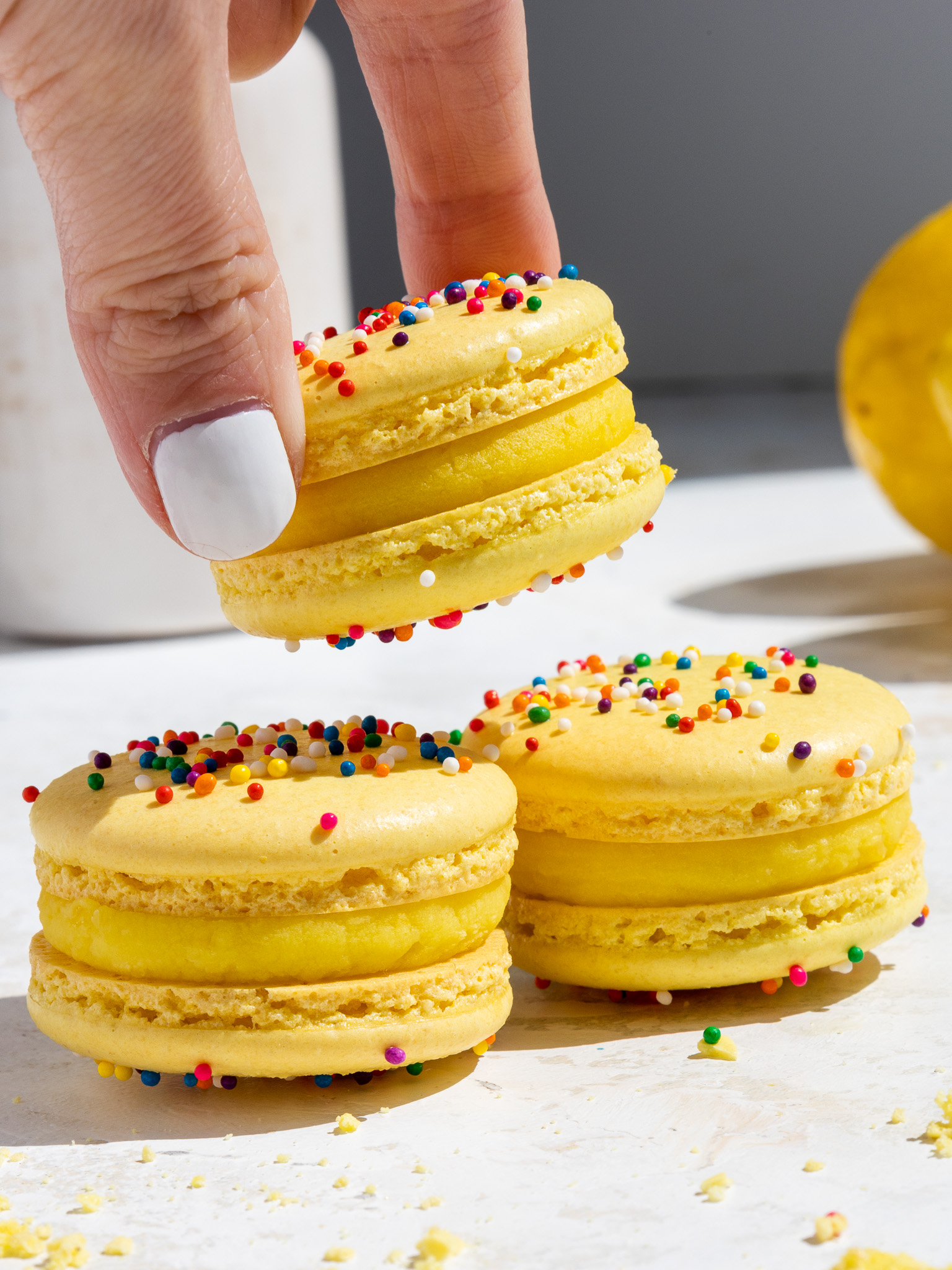 image of macarons filled with lemon ganache being stacked on top of each other