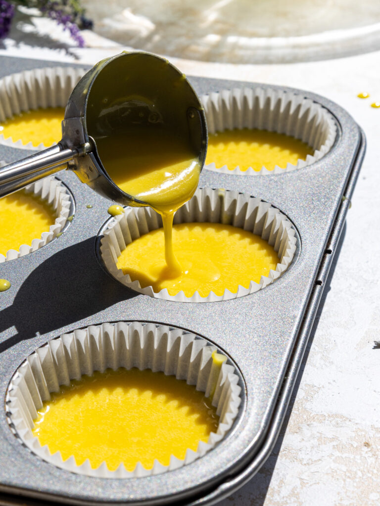 image of lemon cupcake batter that's been poured into cupcake liners in a muffin pan and is ready to be baked