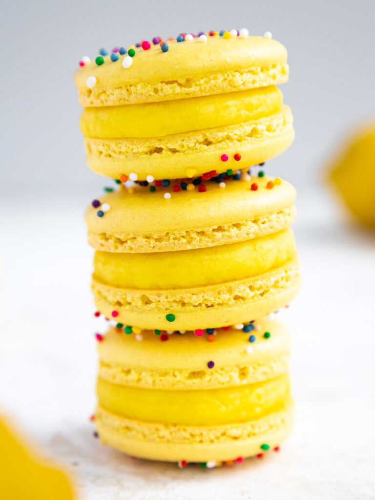 image of lemon macarons that have been filled with lemon white chocolate ganache and have been stacked on each other