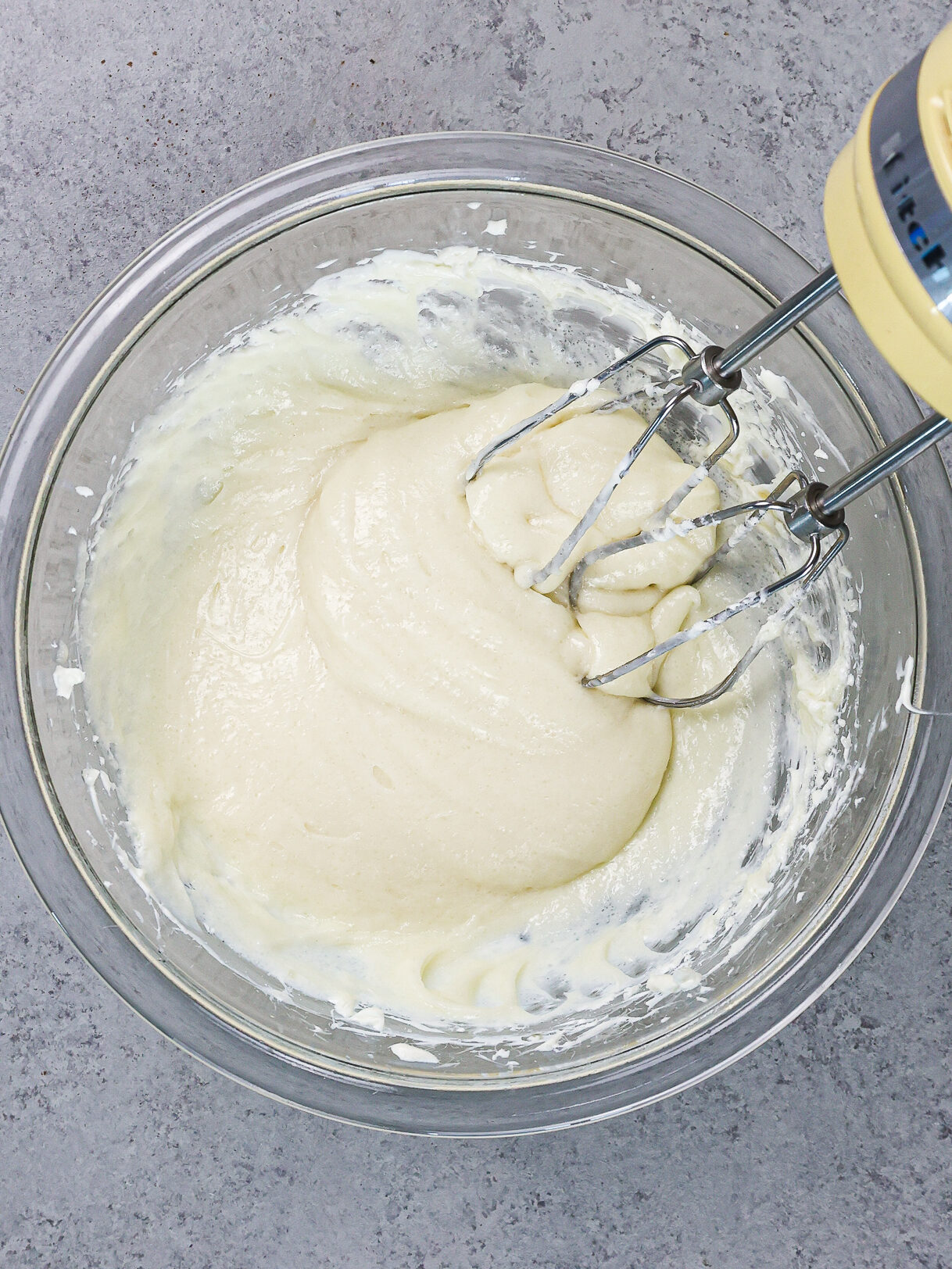 image of cream cheese and sugar being mixed together with a hand mixer