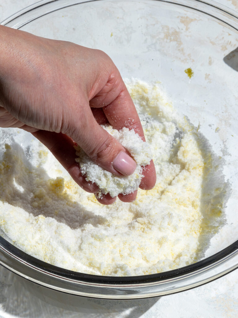 rubbing lemon zest into granulated sugar with fingertips