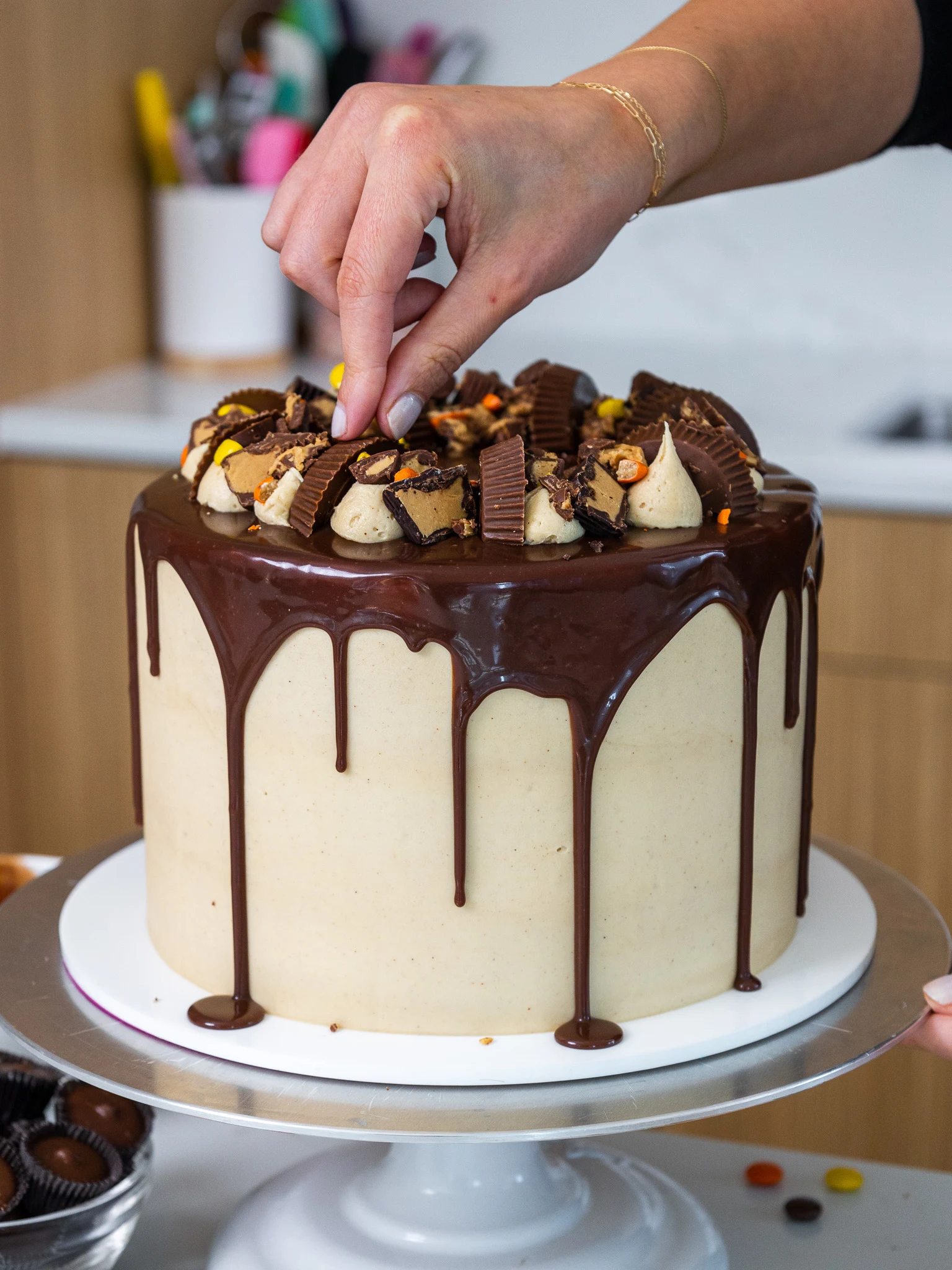 image of a reese's chocolate peanut butter cake that's been decorated with a chocolate drip and reese's candies