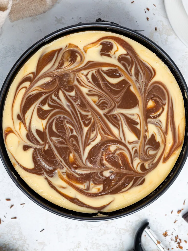 image of a marbled cheesecake that's been baked and is gradually cooling in the cheesecake pan