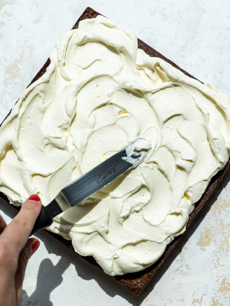 image of whipped cream being spread on top of brownies