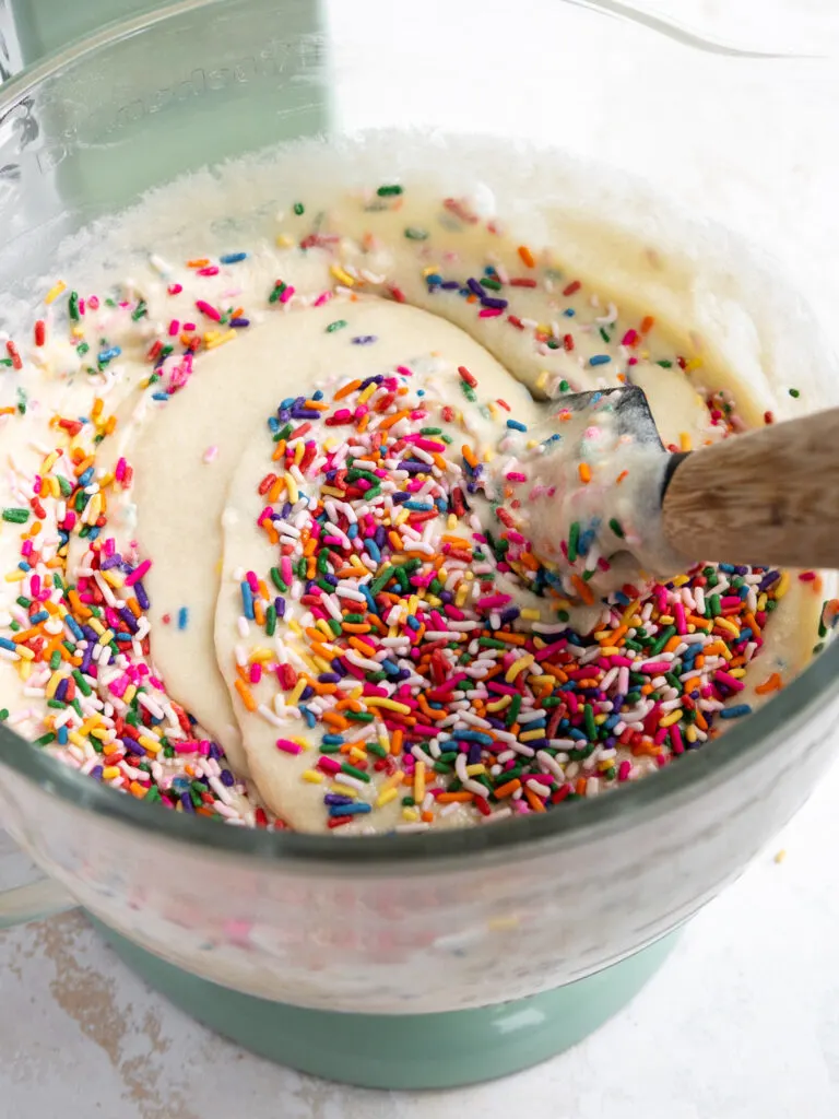image of sprinkles being folded into cake batter to make funfetti cake
