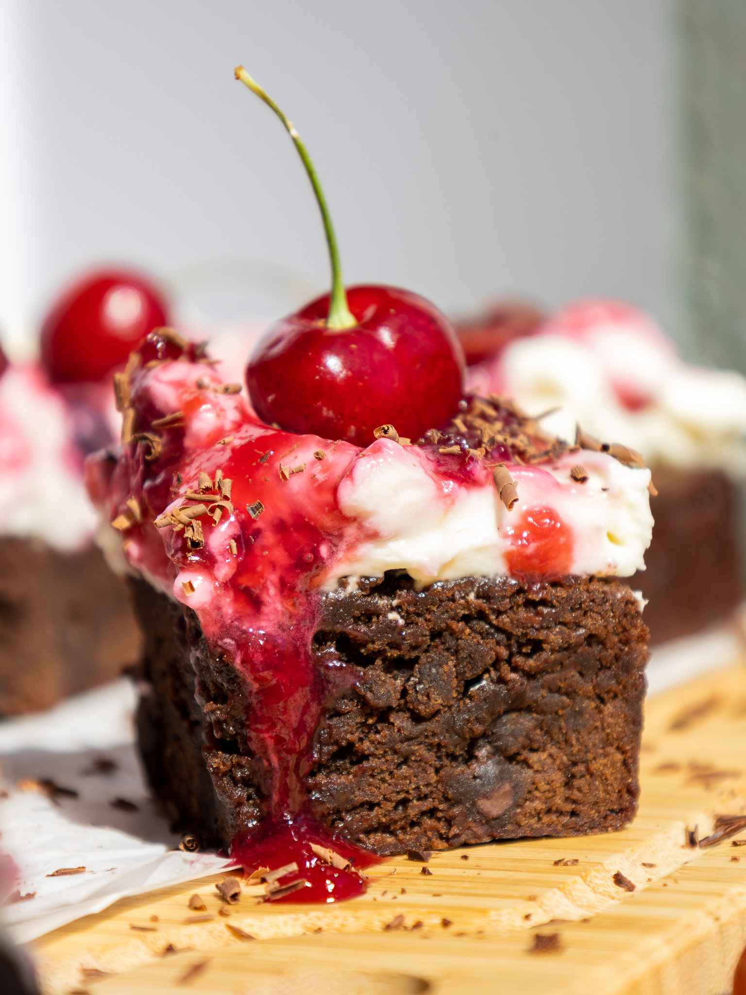 image of a black forest brownie that's been topped with whipped cream and a cherry topping