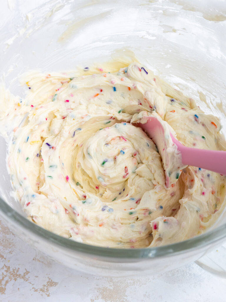 image of sprinkle frosting that's been made in a large glass bowl and is ready to be used