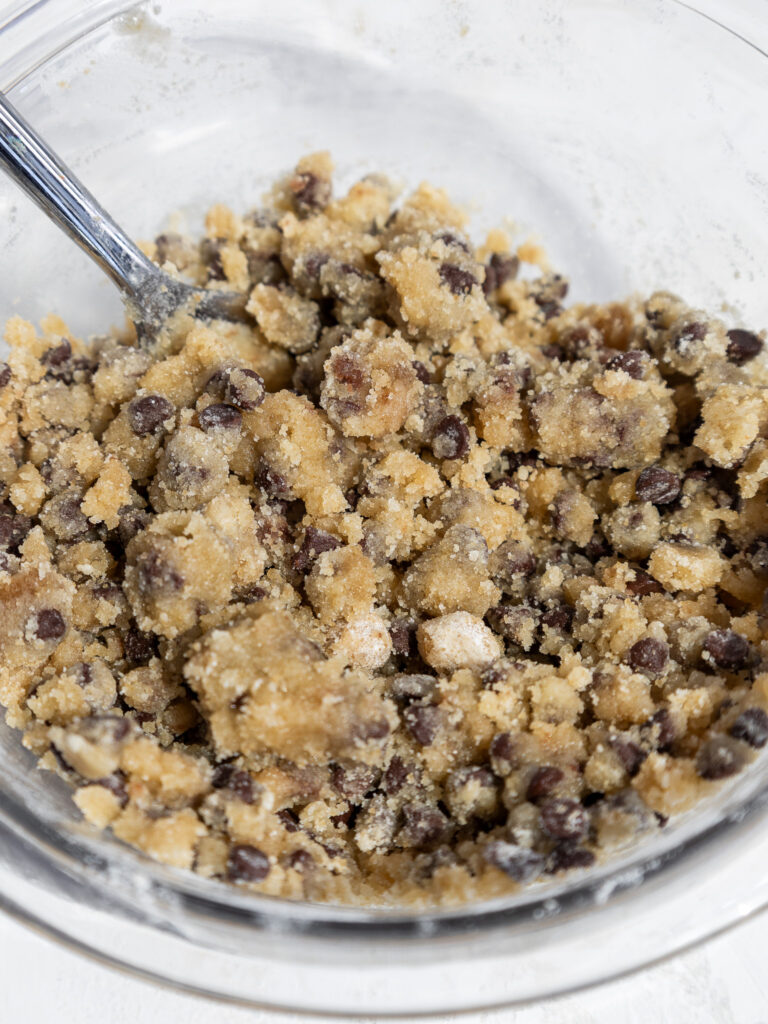 image of chocolate chip streusel that's been made in a glass bowl and mixed with a fork