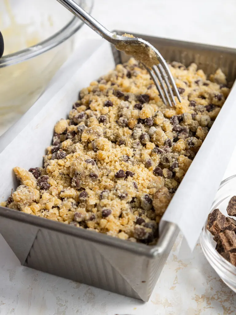 image of chocolate streusel being added on top of marble banana bread batter