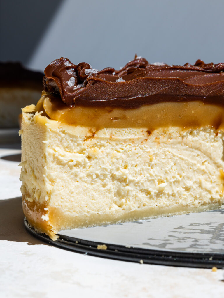 image of a millionaire cheesecake that's been cut into to show it's layers of caramel and chocolate ganache
