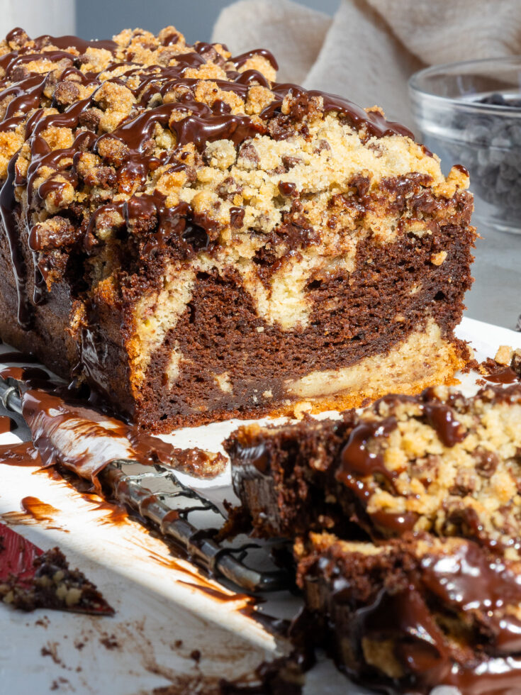 image of marble banana bread that's been topped with chocolate chip streusel and chocolate ganache