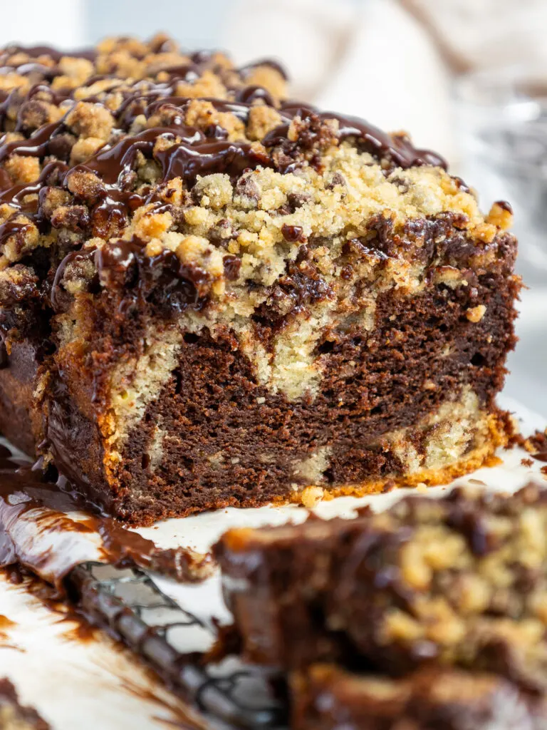image of marble banana bread that's been topped with chocolate chip streusel and chocolate ganache