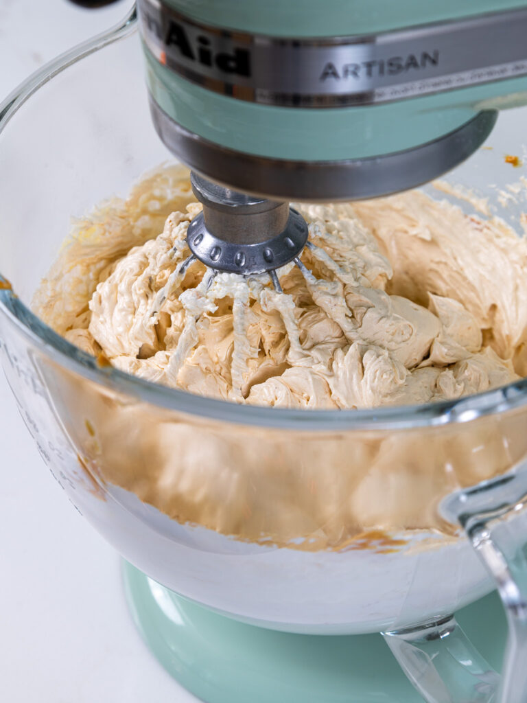 image of peanut butter Swiss meringue buttercream that's been mixed in a stand mixer with a whisk attachment