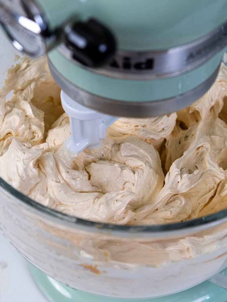 image of peanut butter Swiss meringue buttercream that's been mixed in a stand mixer