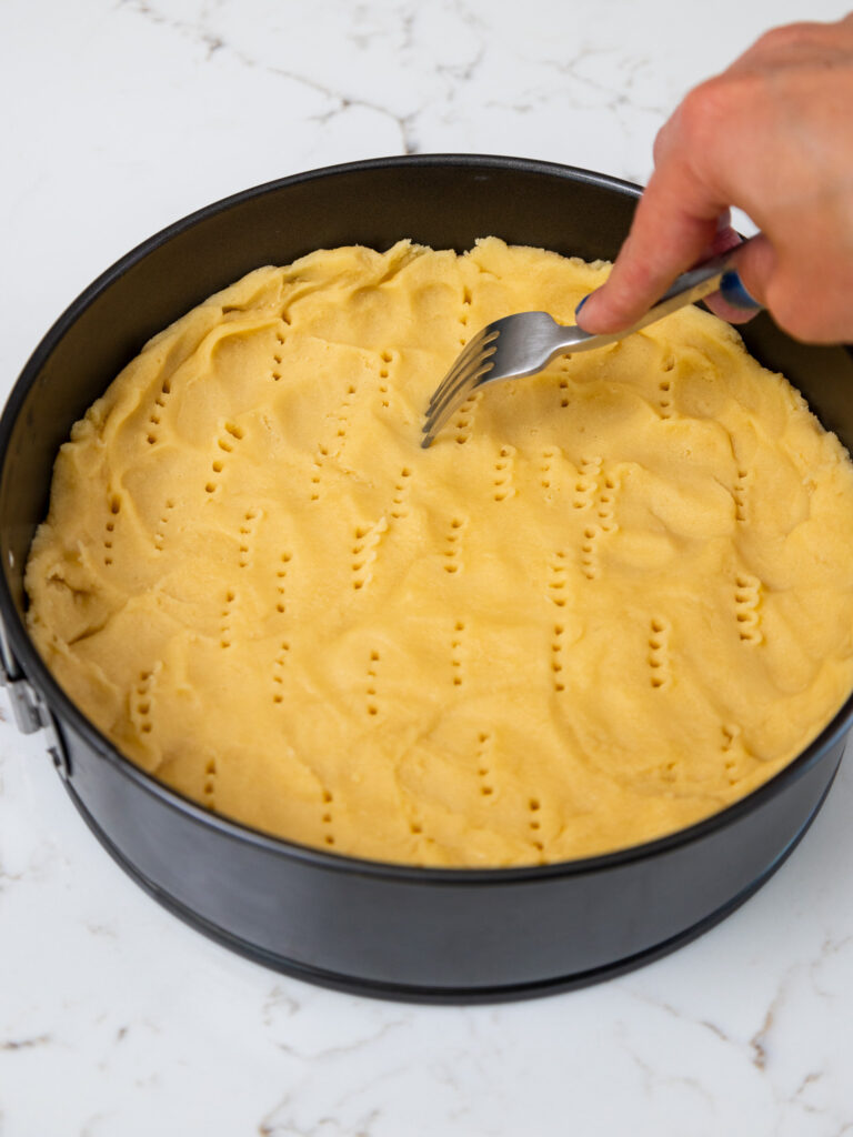 image of a shortbread crust being poked with a fork