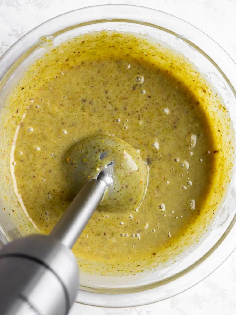 image of pistachio ganache being made with an immersion blender.