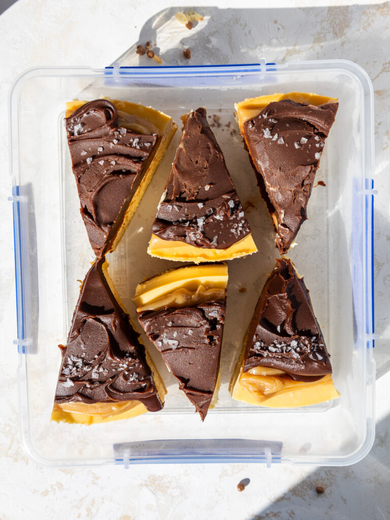 image of slices of millionaire cheesecake being stored in an airtight container