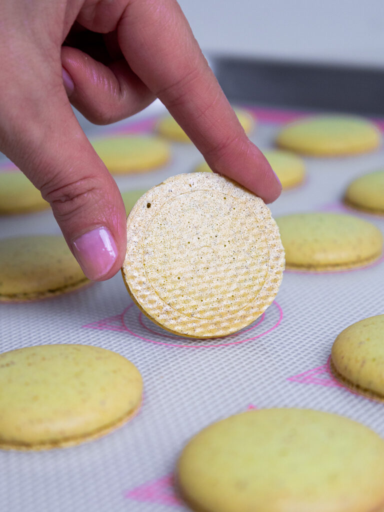 image of pistachio macaron shells that have been properly baked and have shiny bottoms
