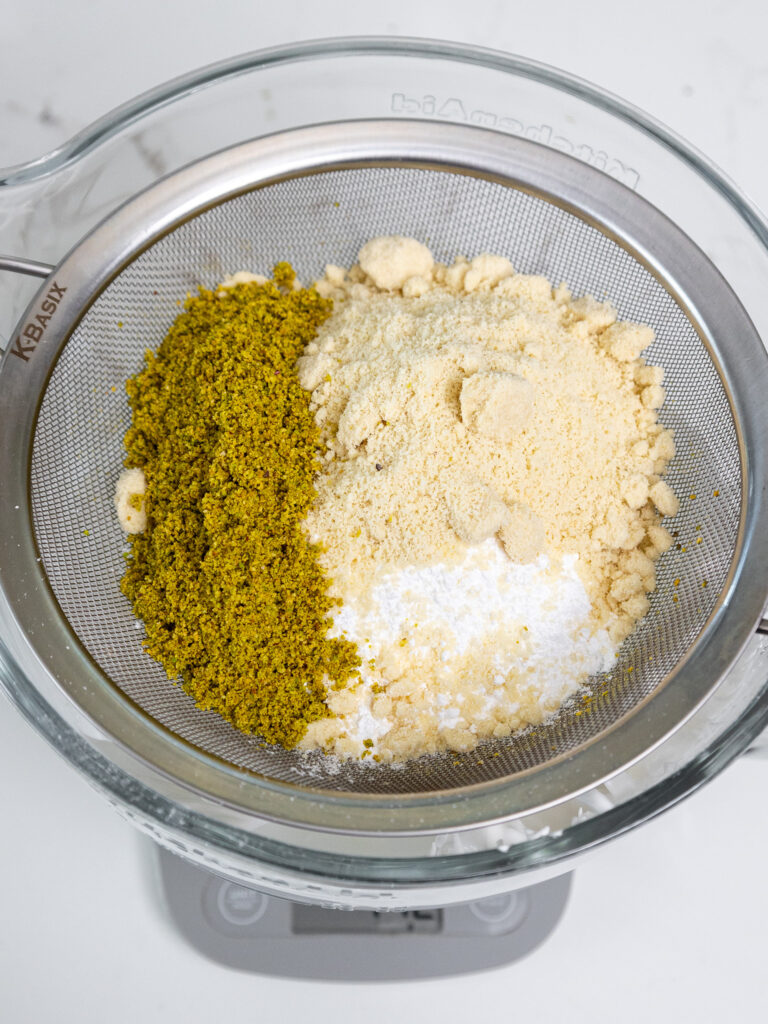 image of dry ingredients being sifter through a fine mesh sifter