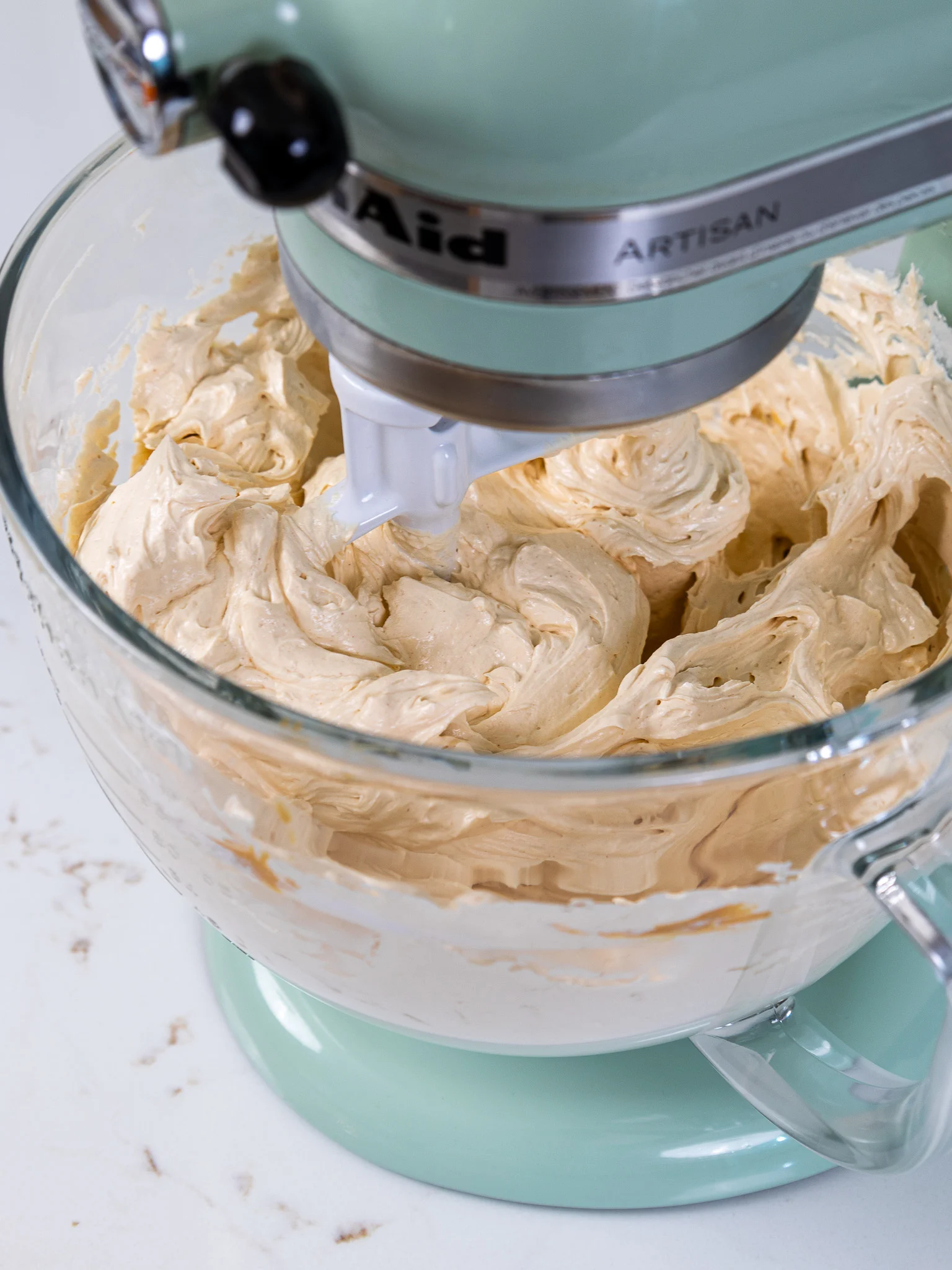 image of peanut butter Swiss meringue buttercream that's been mixed in a stand mixer