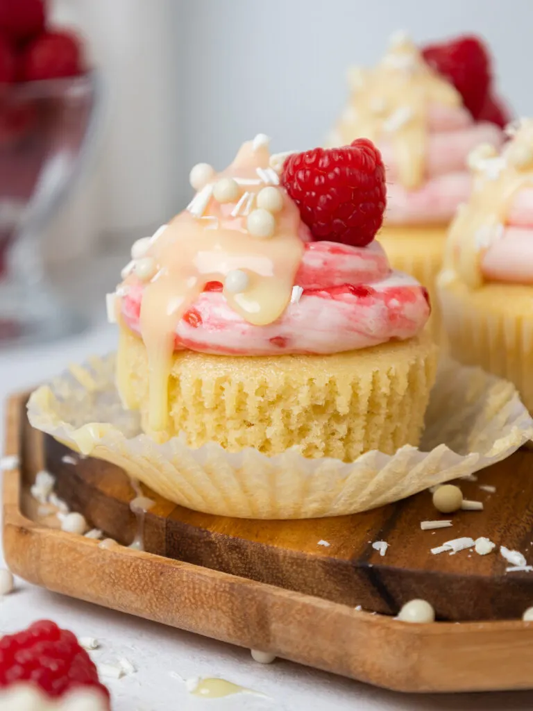 image of a white chocolate raspberry cupcake that's been unwrapped from its liner