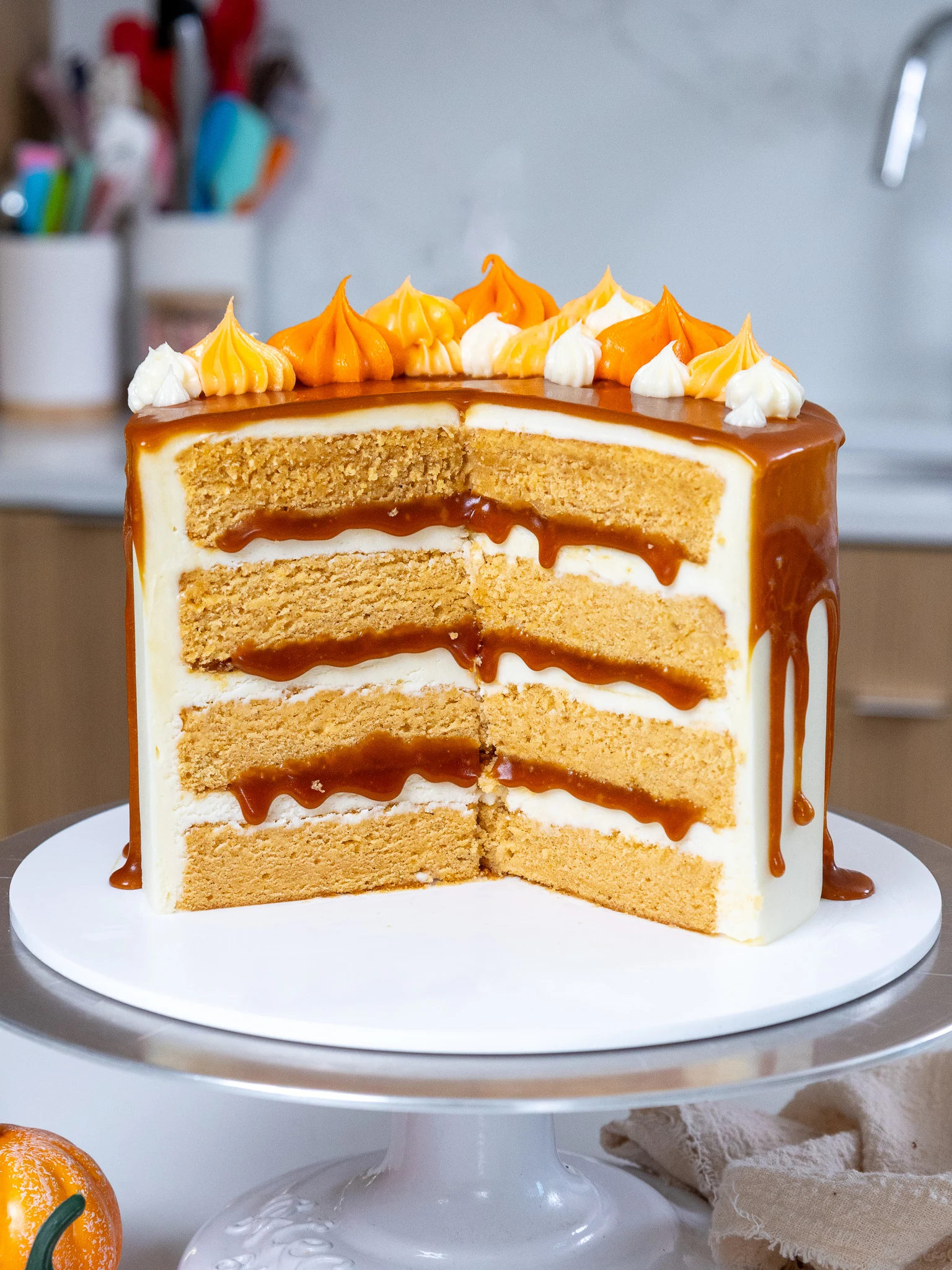 image of a pumpkin caramel layer cake that's been cut into to show its moist pumpkin can layers and caramel filling