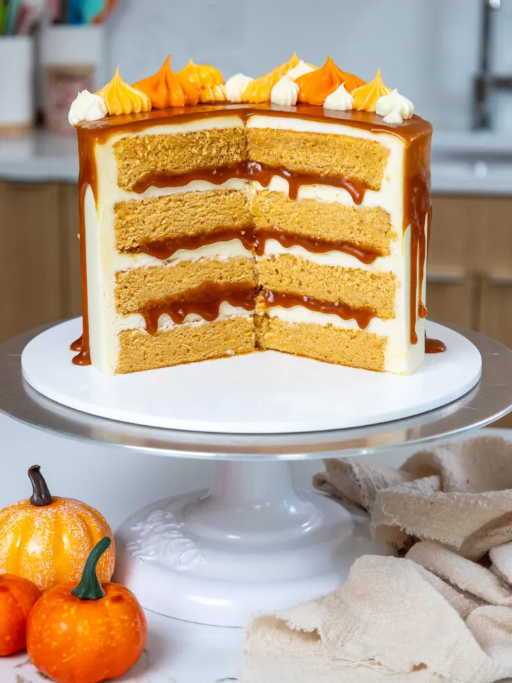 image of a pumpkin caramel layer cake that's been cut into to show its moist pumpkin can layers and caramel filling