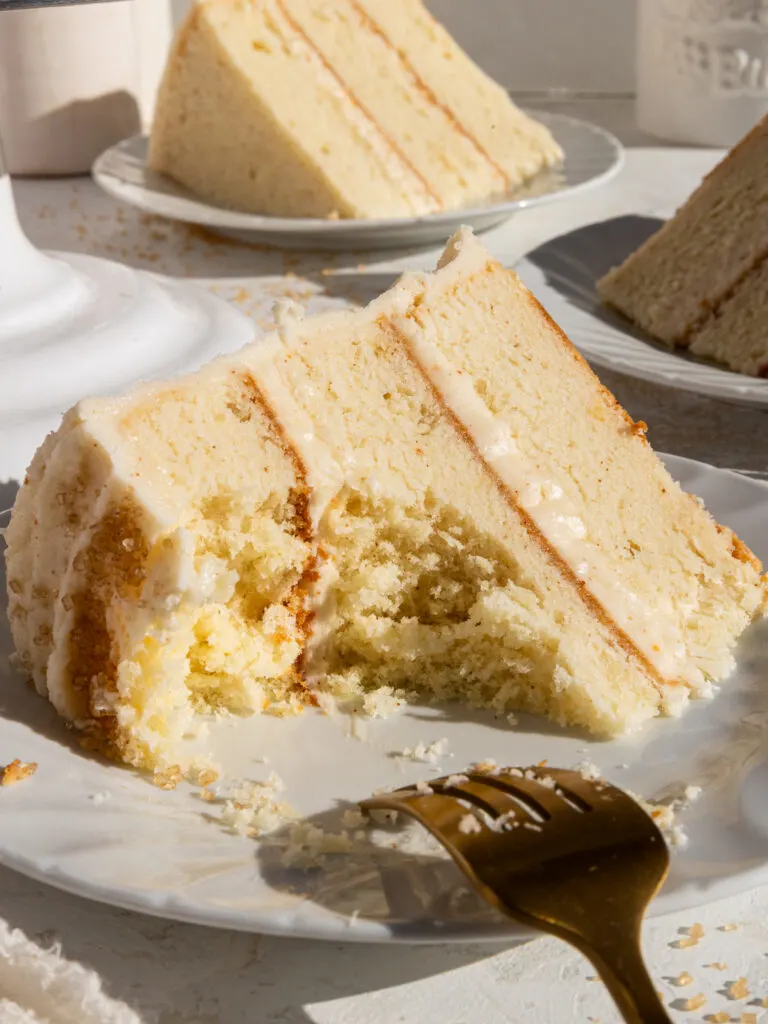 image of a slice of brown butter cake that's been cut into to show how tender its cake layers are