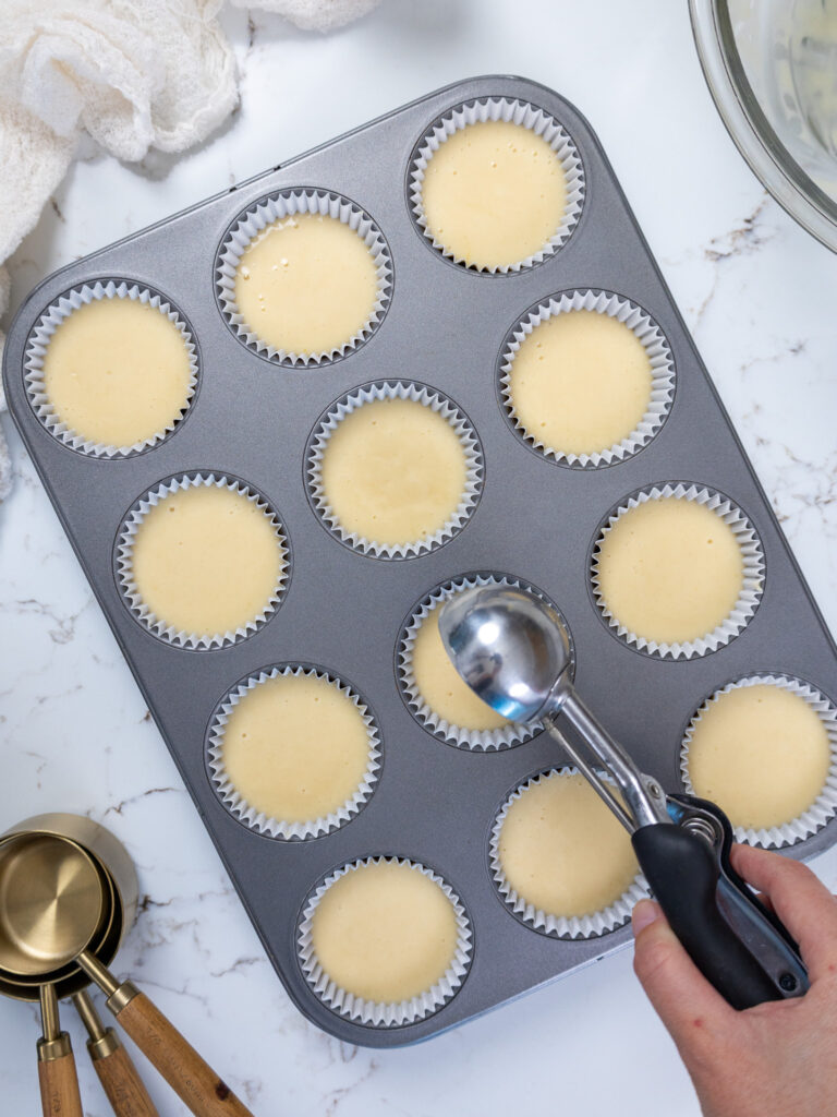 image of a muffin pan being filled with cupcake batter