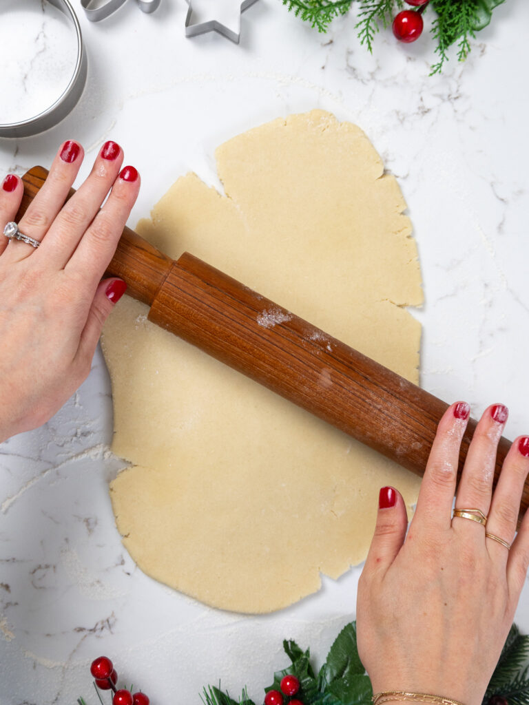 image of cream cheese cookie dough being rolled out with a rolling pin