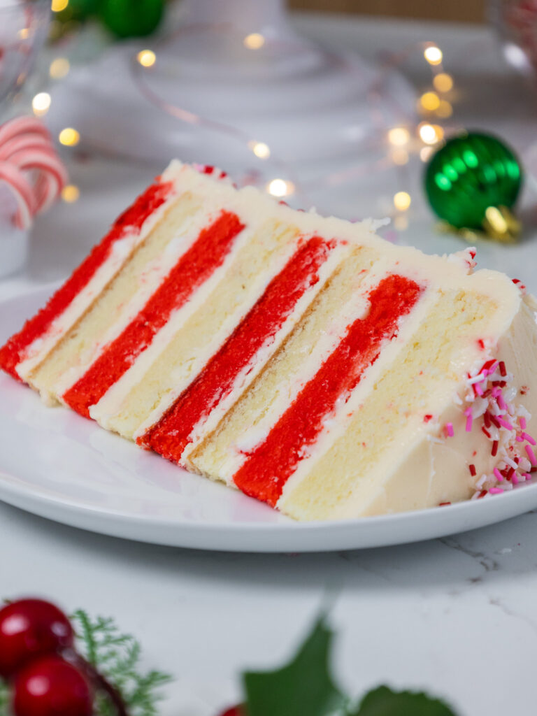 image of a candy cane cake that's been made with red and white cake layers and candy cane buttercream