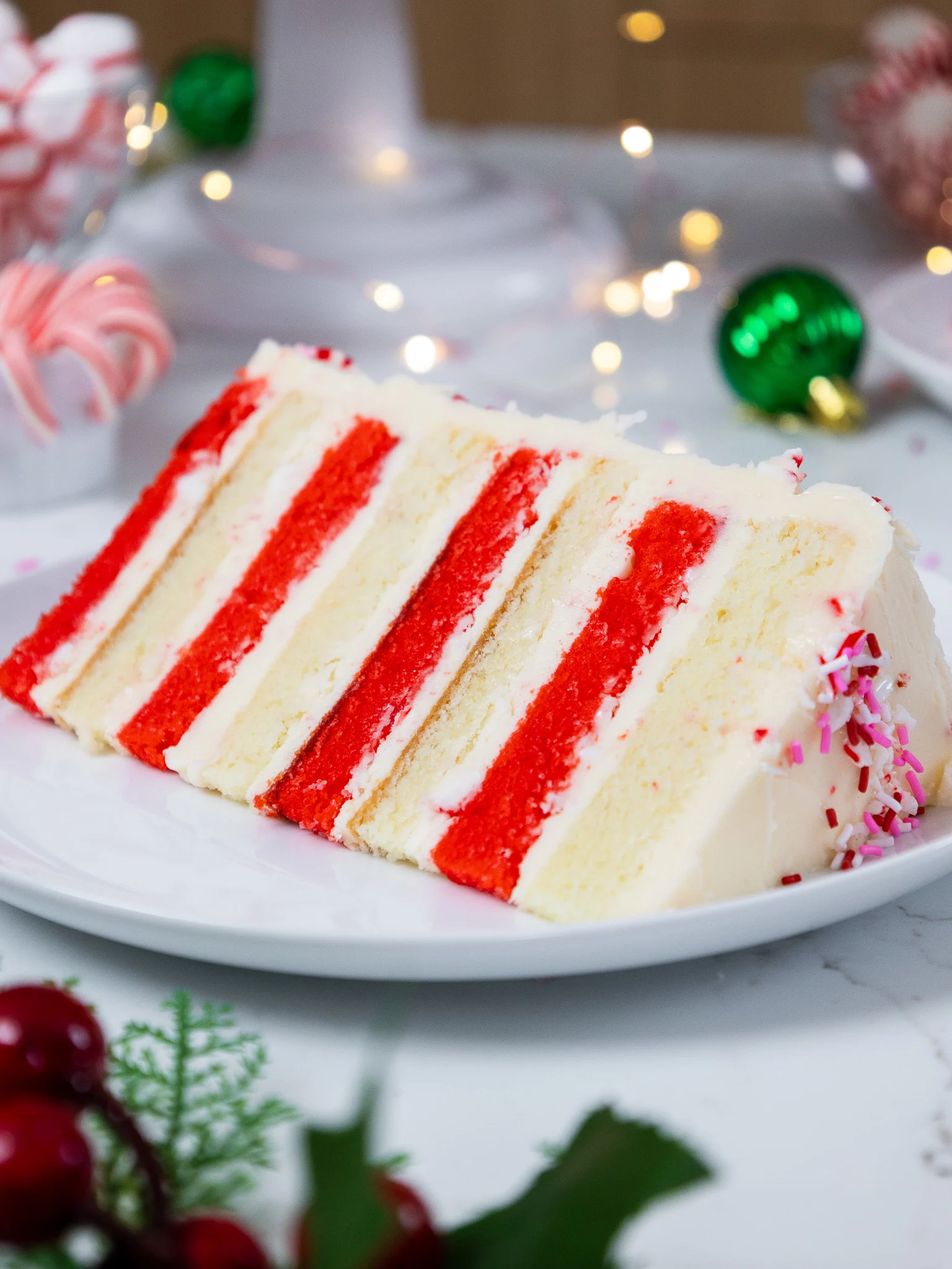 image of a candy cane cake that's been made with red and white cake layers and candy cane buttercream