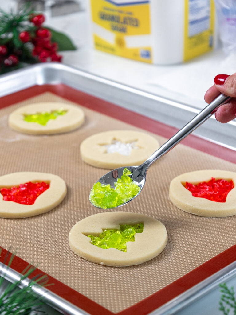 image of crushed hard candies being added into the center of a cookie with a spoon