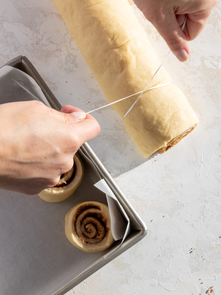 image of cinnamon rolls being cut with dental floss