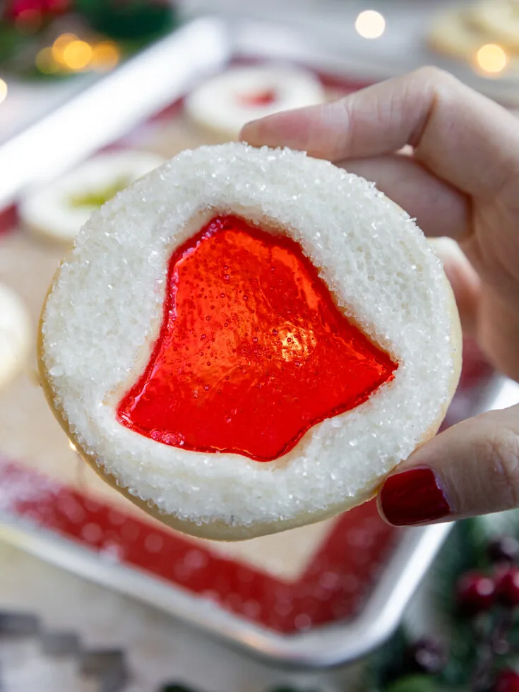 image of a stained glass Christmas cookie being held up to show its candy center