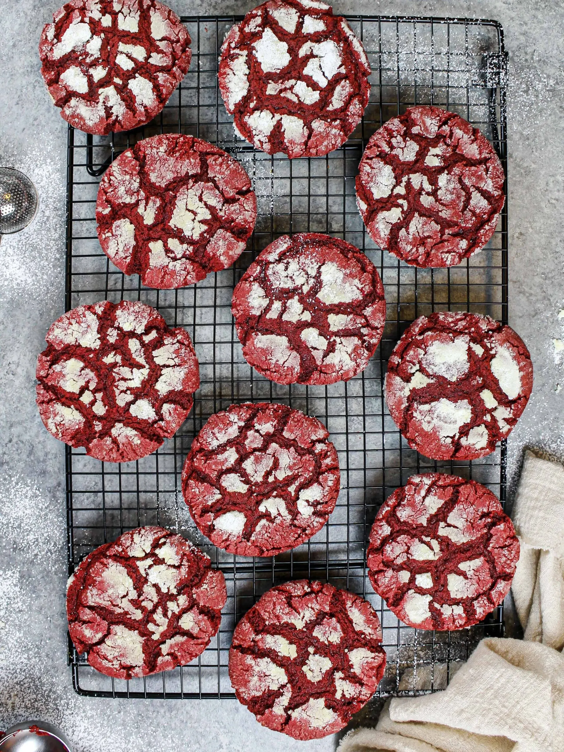 image of red velvet crinkle cookies made from scratch cooling on a wire rack