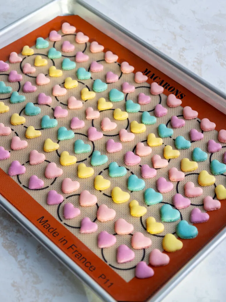 image of baked mini heart shaped macaron shells that have been baked to make mini conversation heart macarons