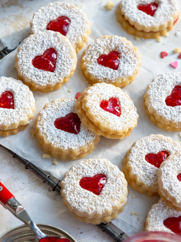 image of raspberry linzer cookies that are laid out on parchment paper