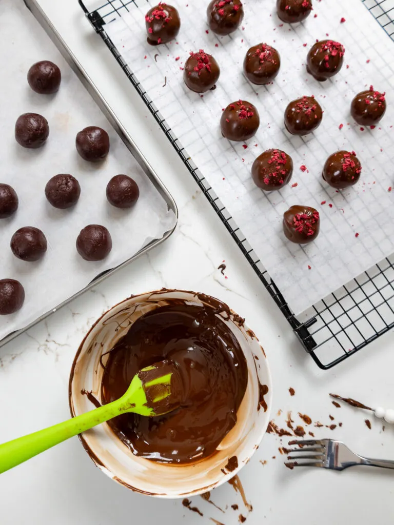 image of raspberry chocolate truffles being dipped in dark chocolate