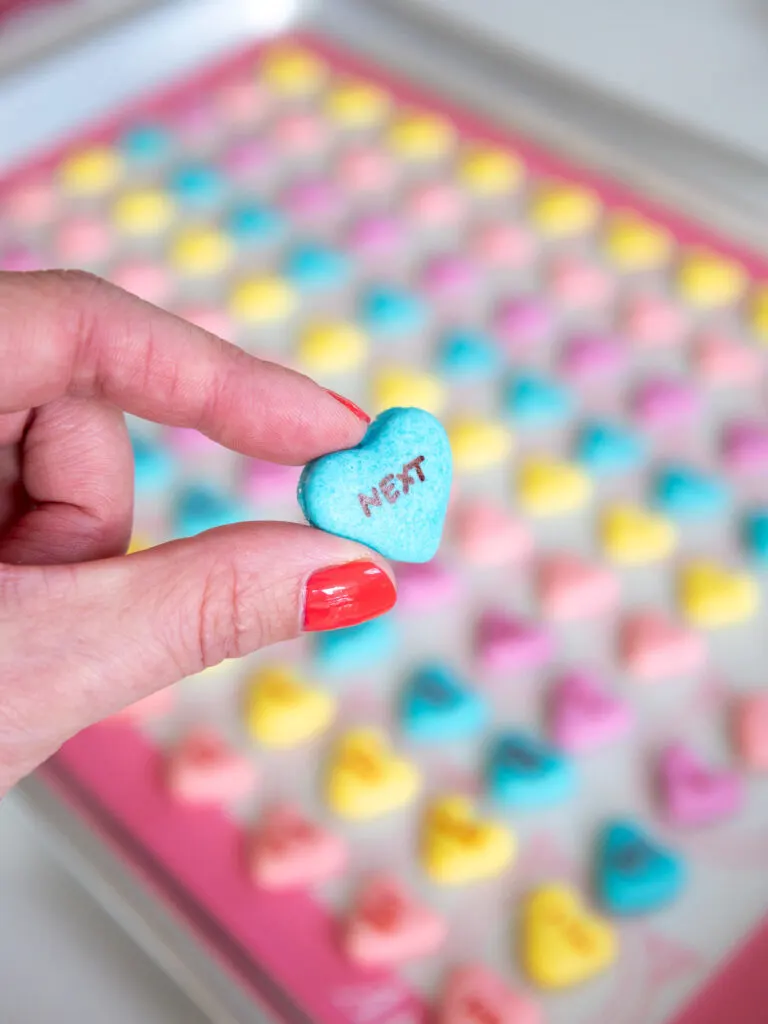 image of a conversation heart macaron that's been filled with American buttercream