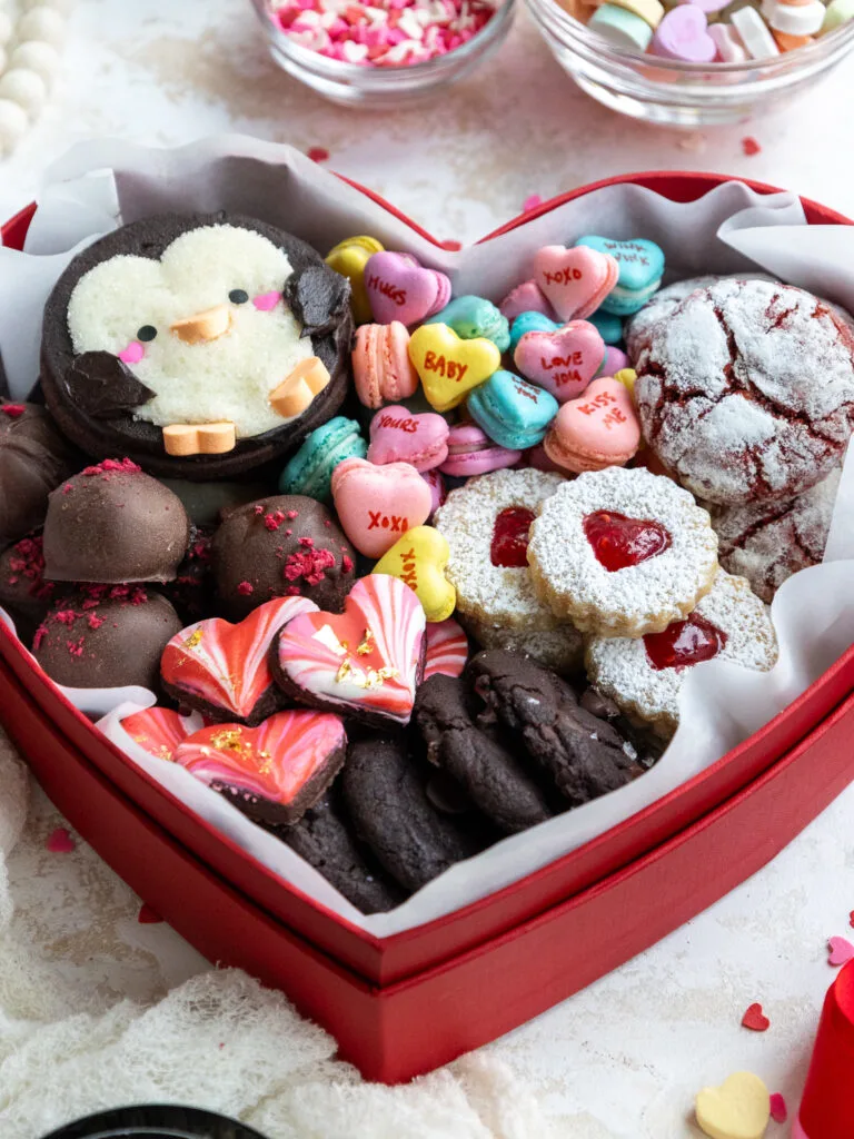 image of a cute valentine's day dessert box that's been filled with an assortment of cookies a truffles