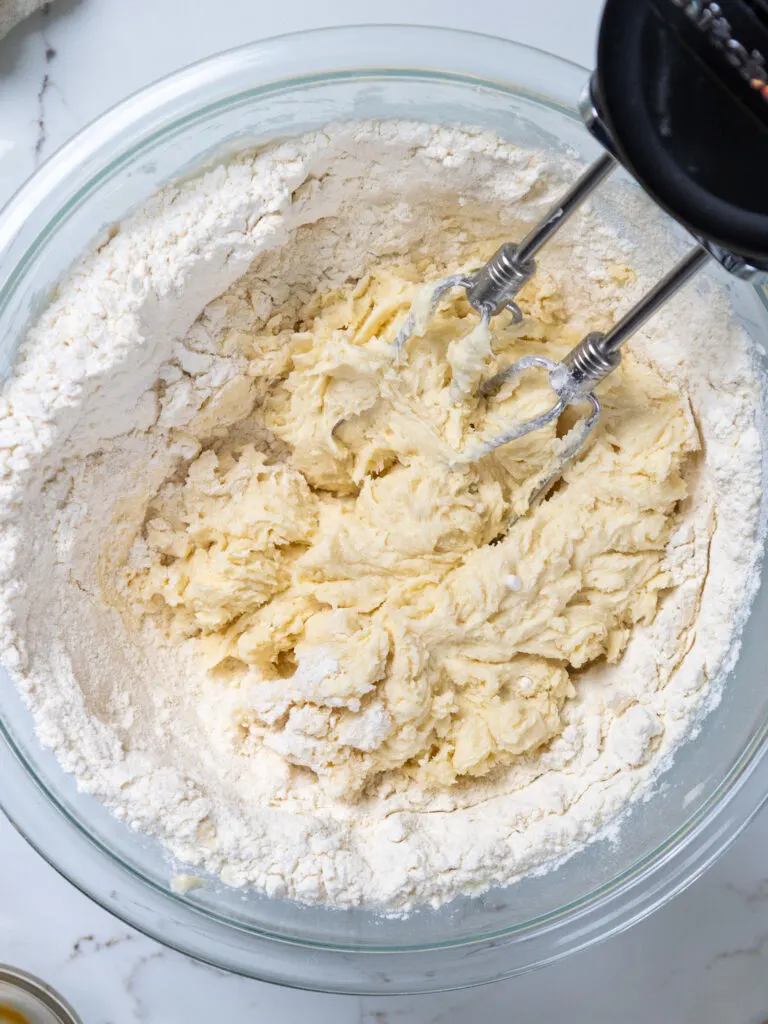 image of dry ingredients being mixed into wet ingredients with a hand mixer
