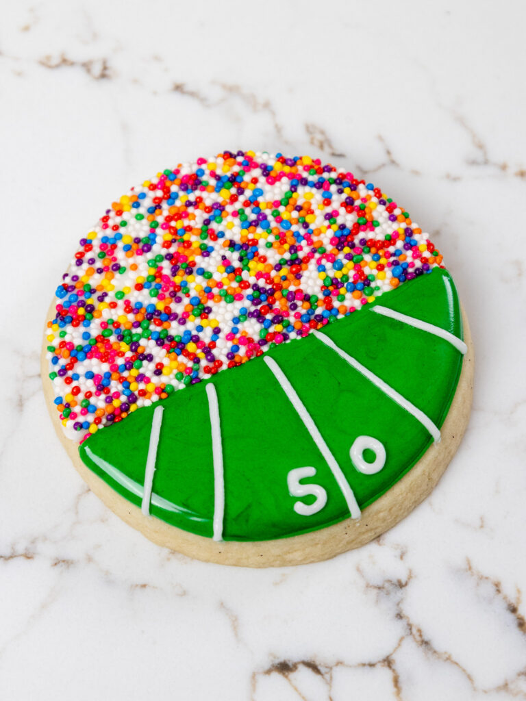 image of a football field cookie decorated with sprinkles and royal icing