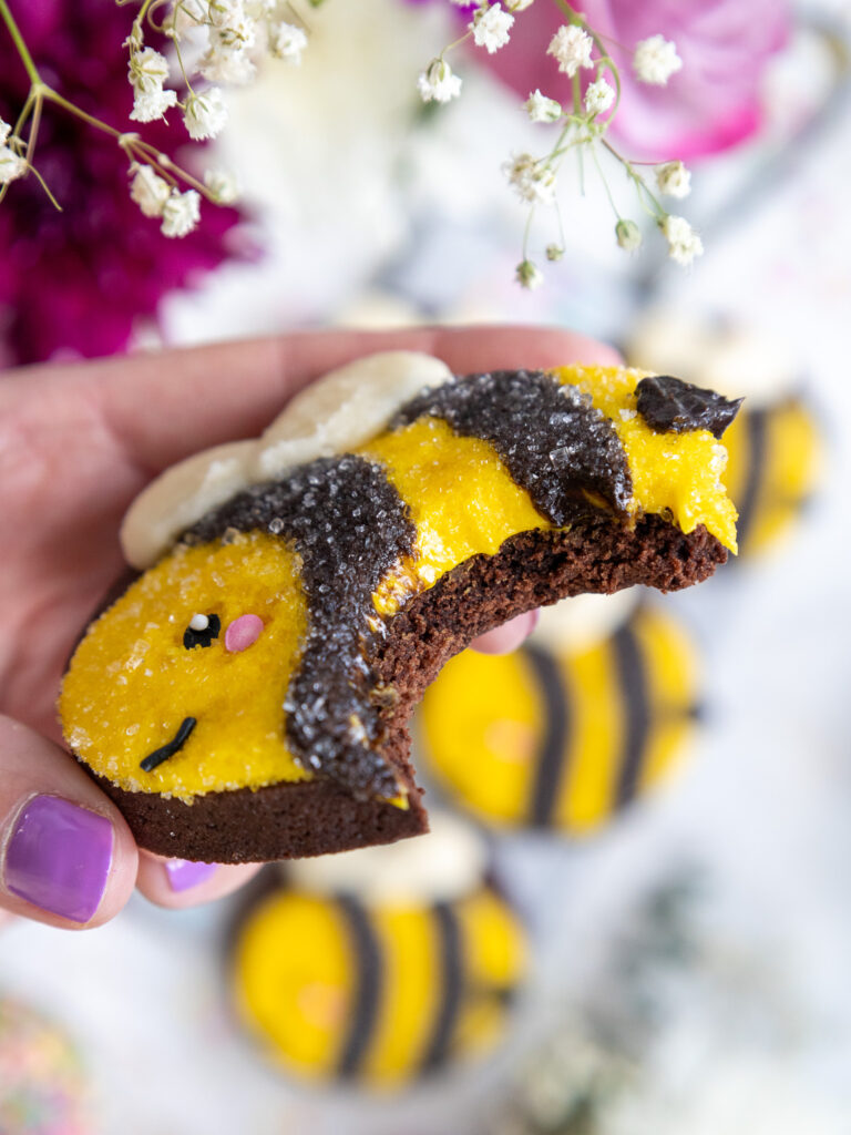 image of a cute bumble bee cookie that's been bitten into to show how soft and chewy it is