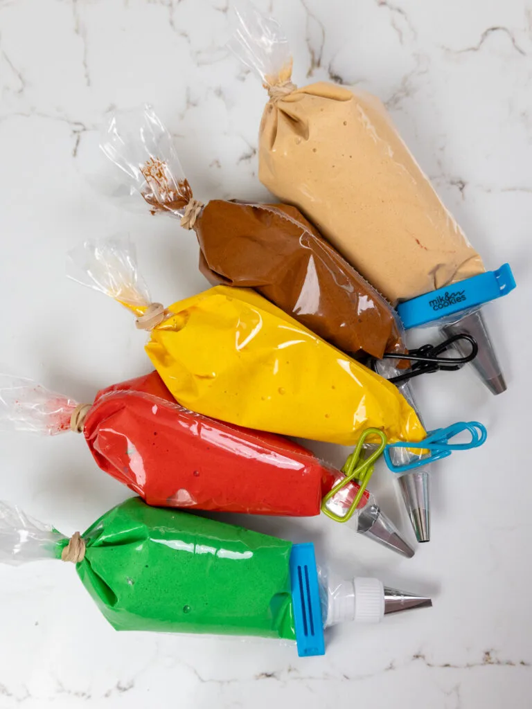image of colorful macaron batter in piping bags ready to be used to make burger macarons