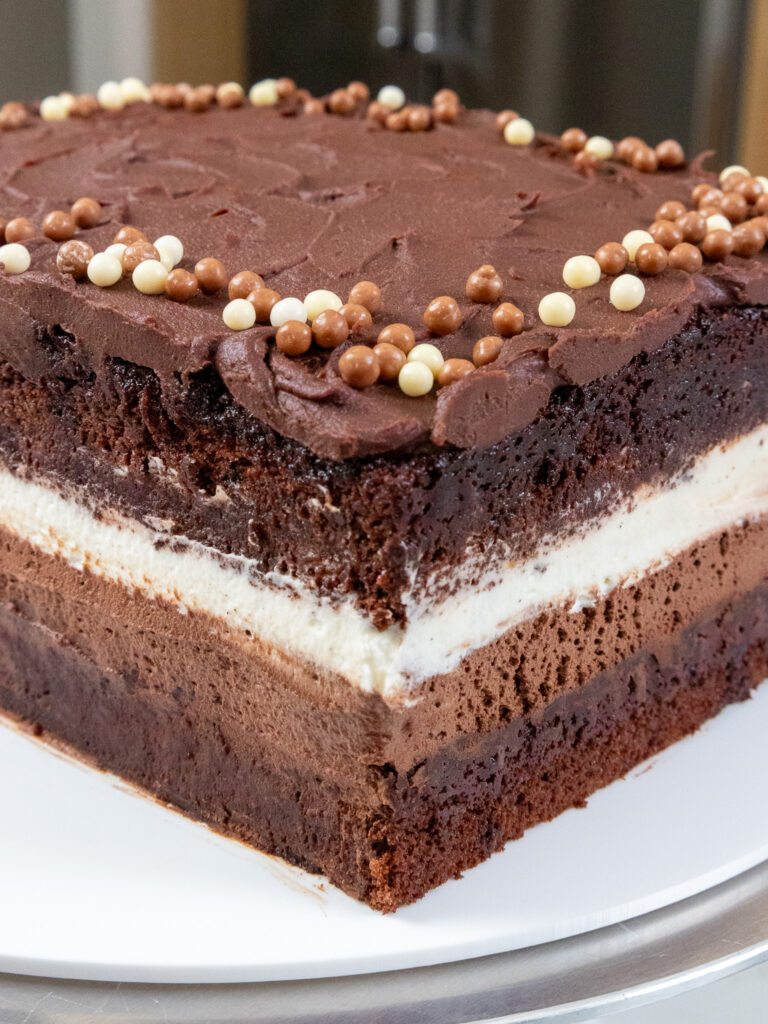 image of a chocolate tuxedo cake that's filled with dark and white chocolate mousse and topped with dark chocolate ganache frosting